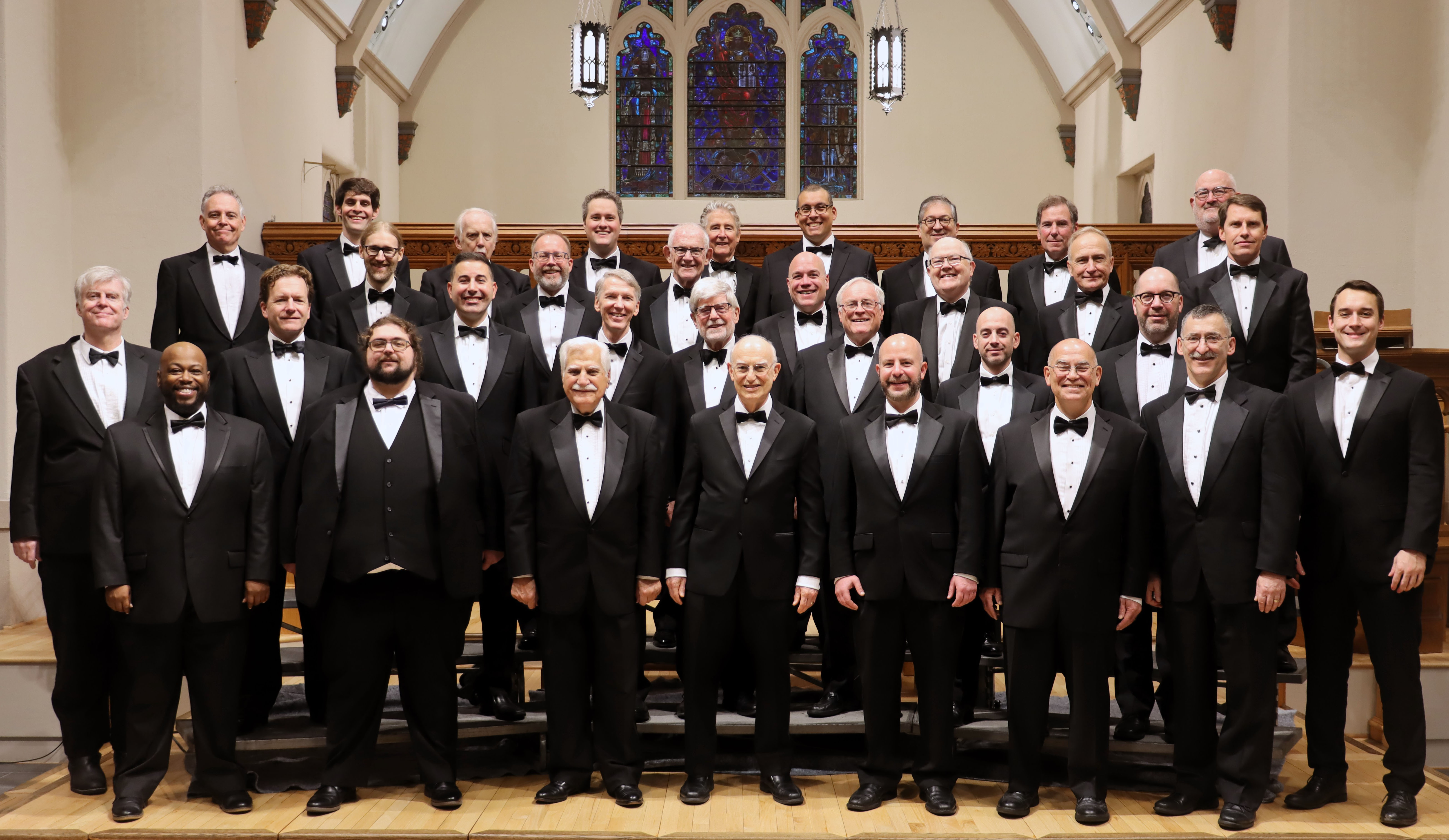 A group of men posing on a stage, smiling.