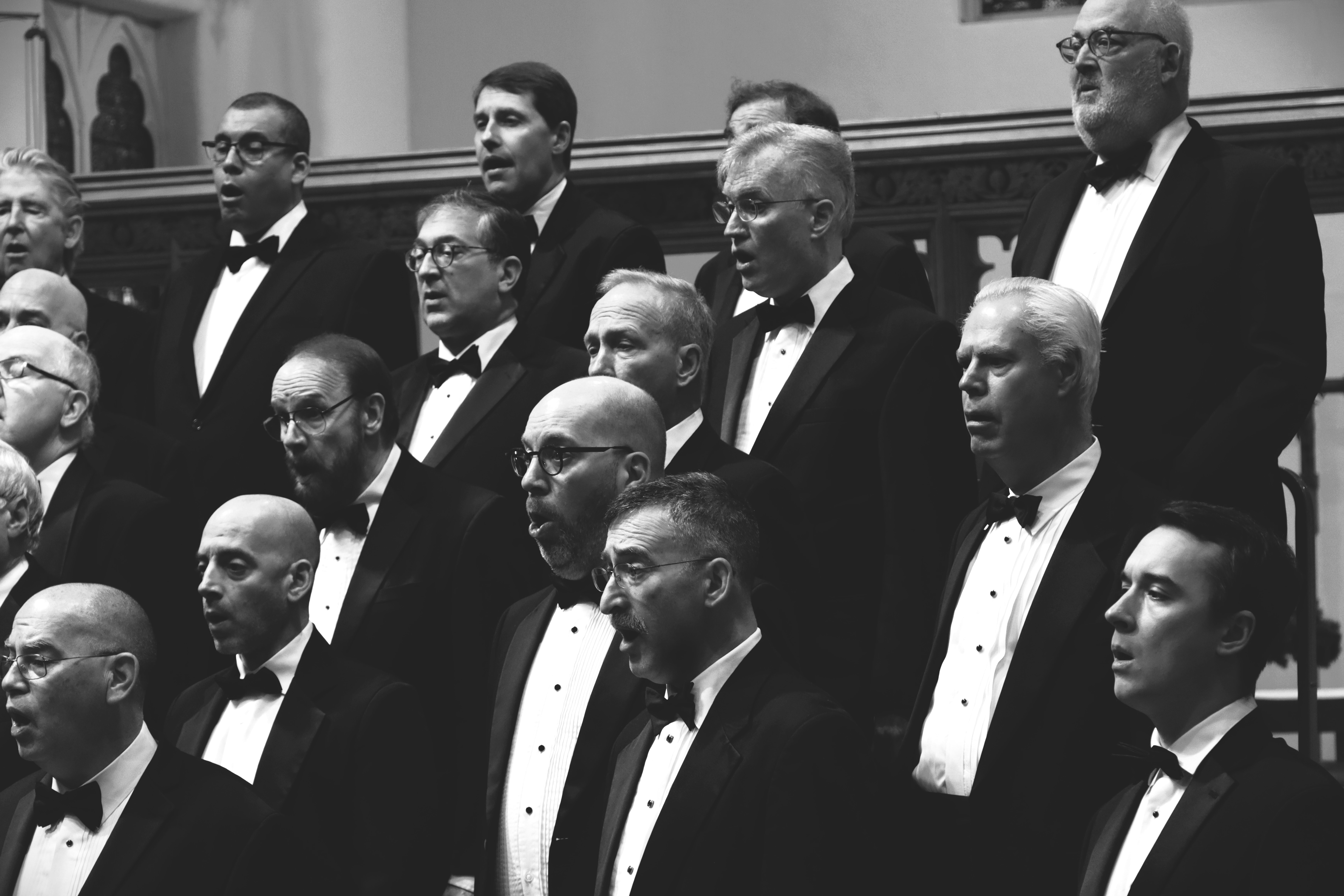 A group of men on a stage, singing.