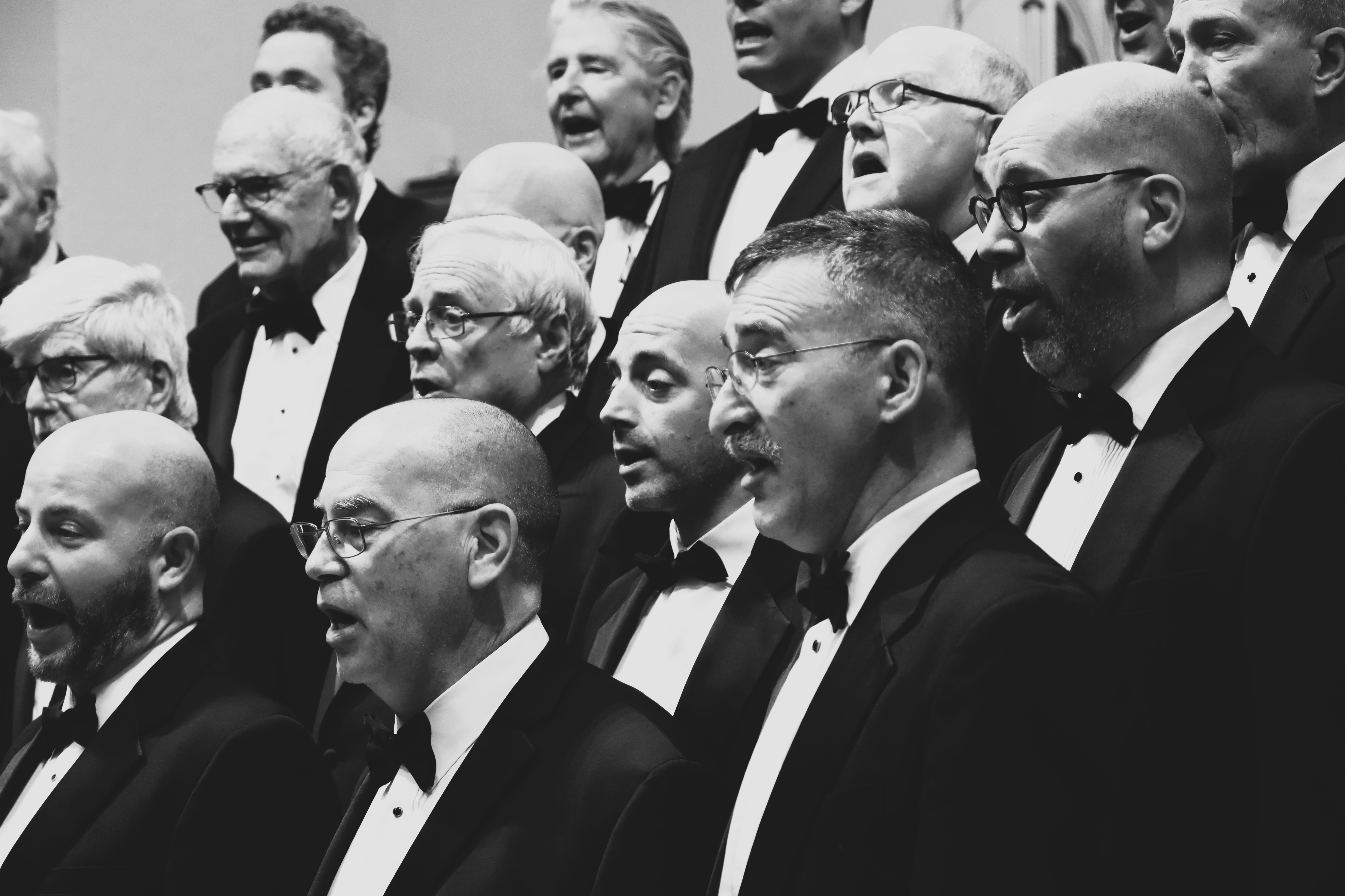 A group of men on a stage, singing.