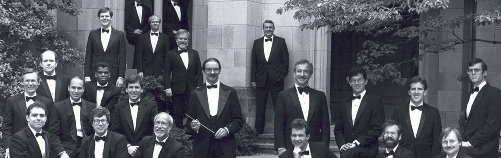 A group of men posing in a graveyard.
