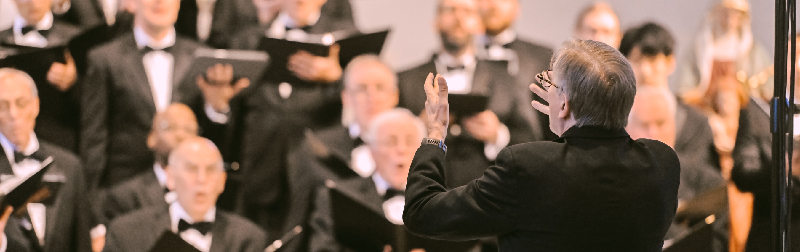 The Washington Men’s Camerata performing behind its conductor.