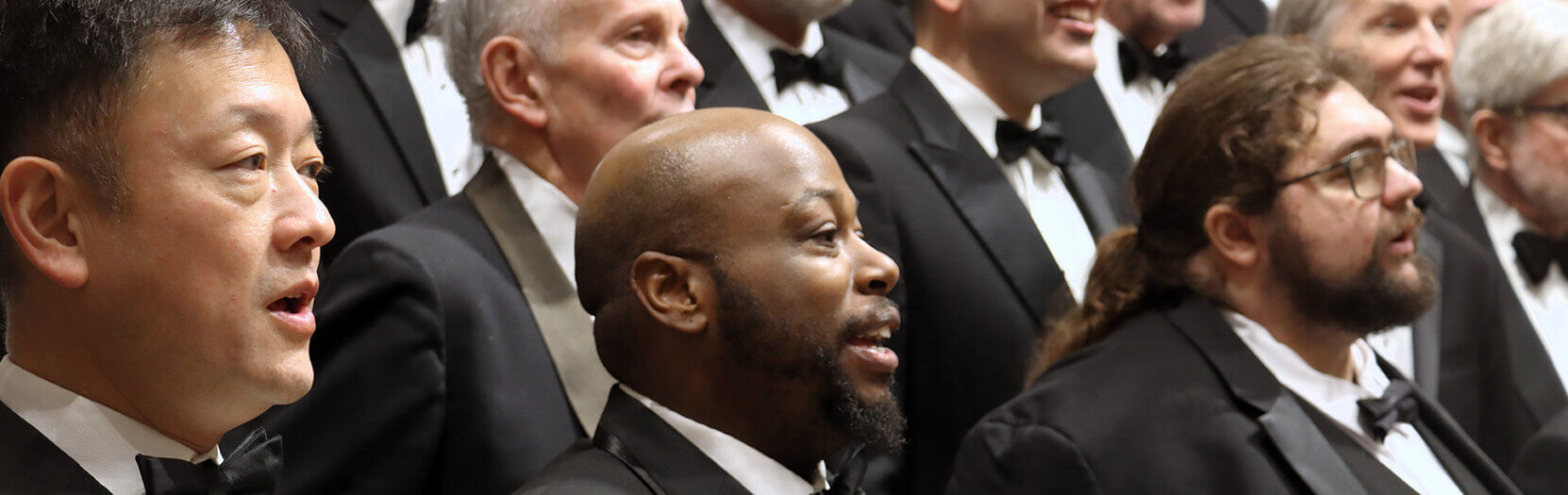 Washington Men’s Camerata singers performing in tuxedos.